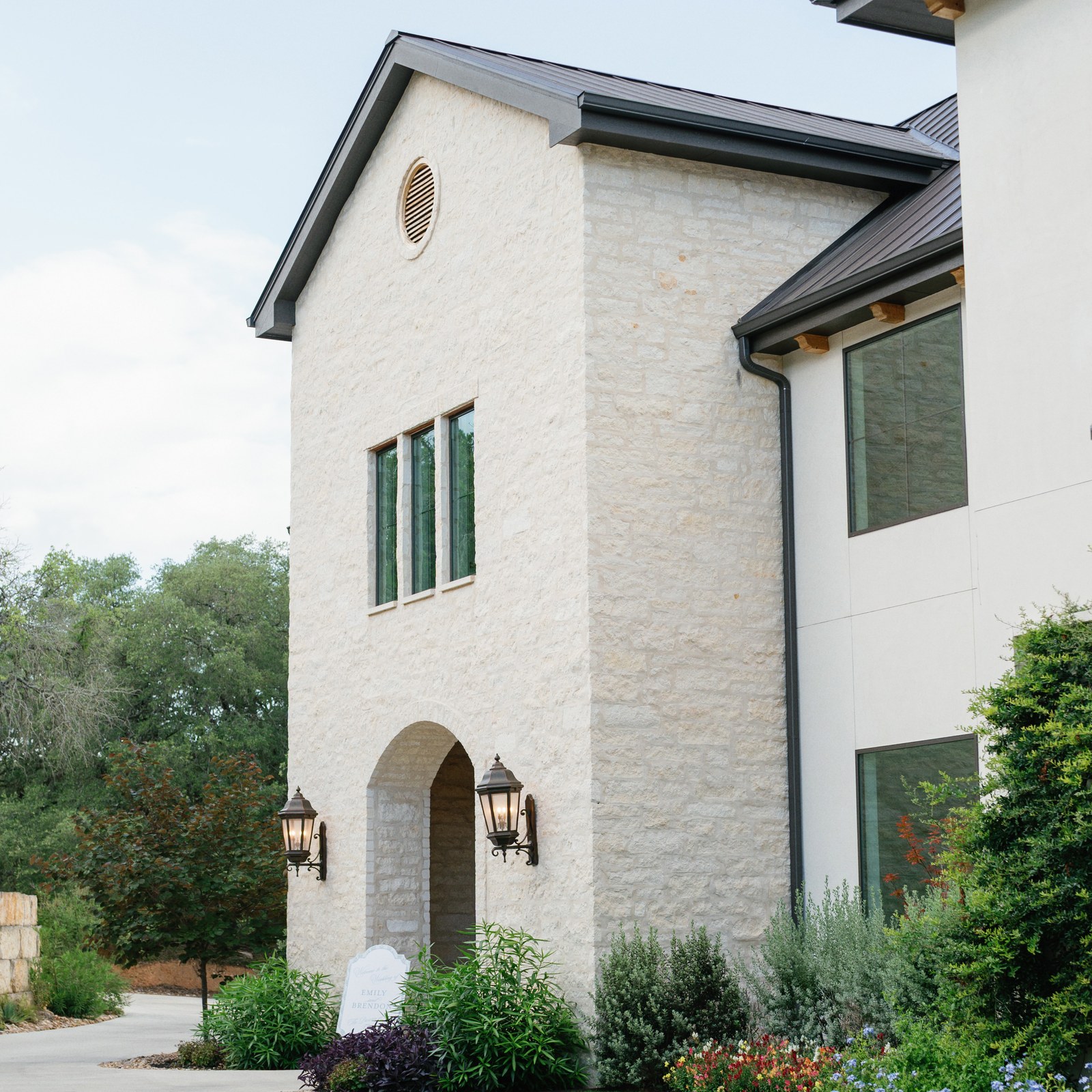 Limestone entrance tower with arched doorway and lanterns at The Preserve at Canyon Lake